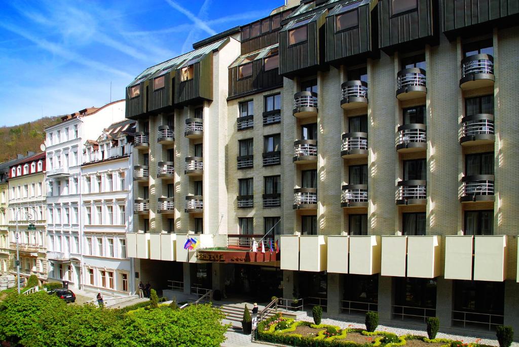 un gran edificio con balcones en un lateral en Hotel Bristol, en Karlovy Vary