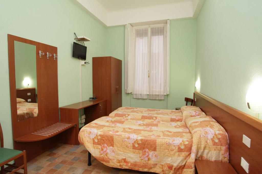 a hotel room with a bed and a mirror at Hotel Barone in Genoa