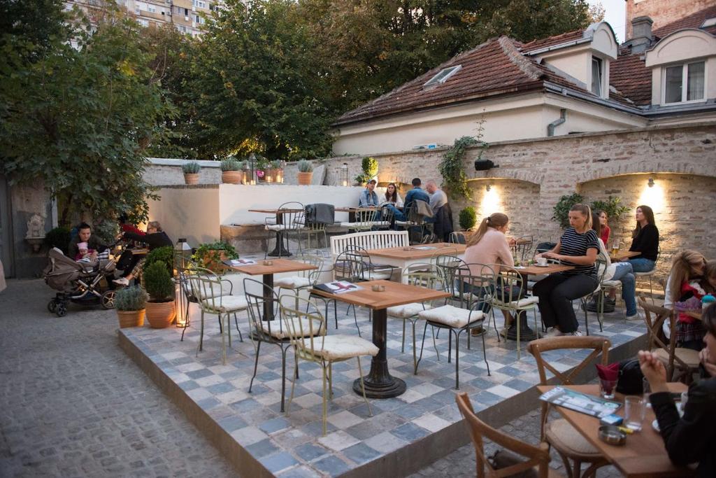 a group of people sitting at tables in a patio at Smokvica Dorćol B&B in Belgrade