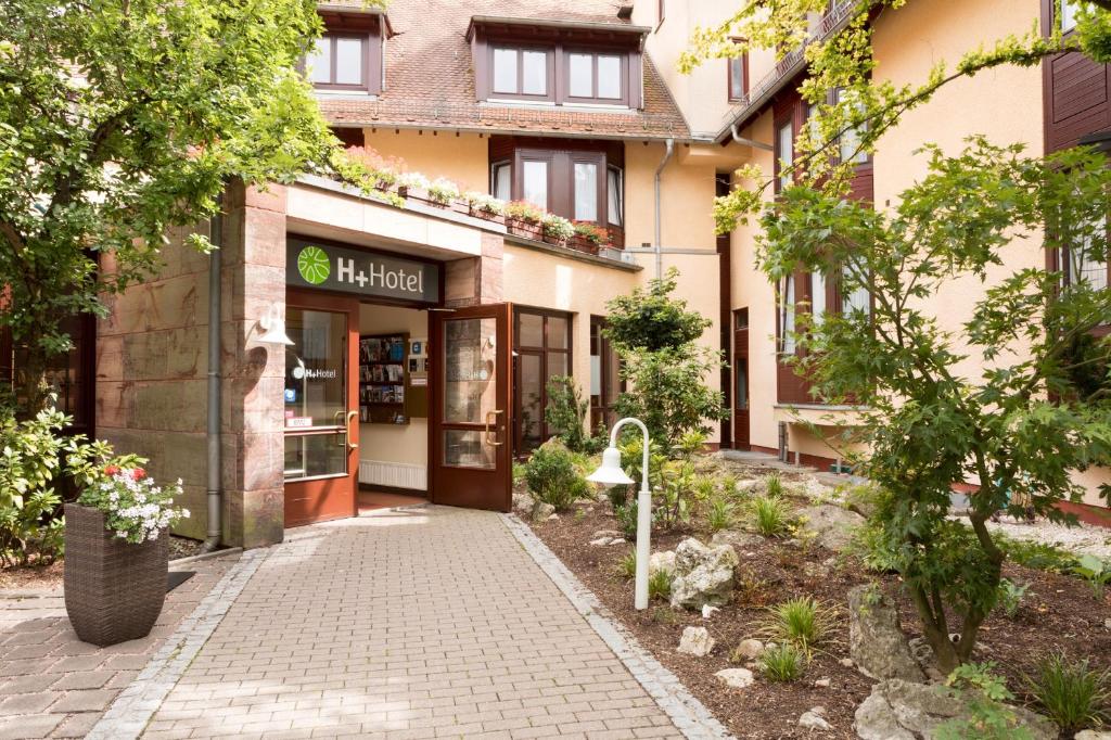 a building with a walkway in front of it at H+ Hotel Nürnberg in Nuremberg