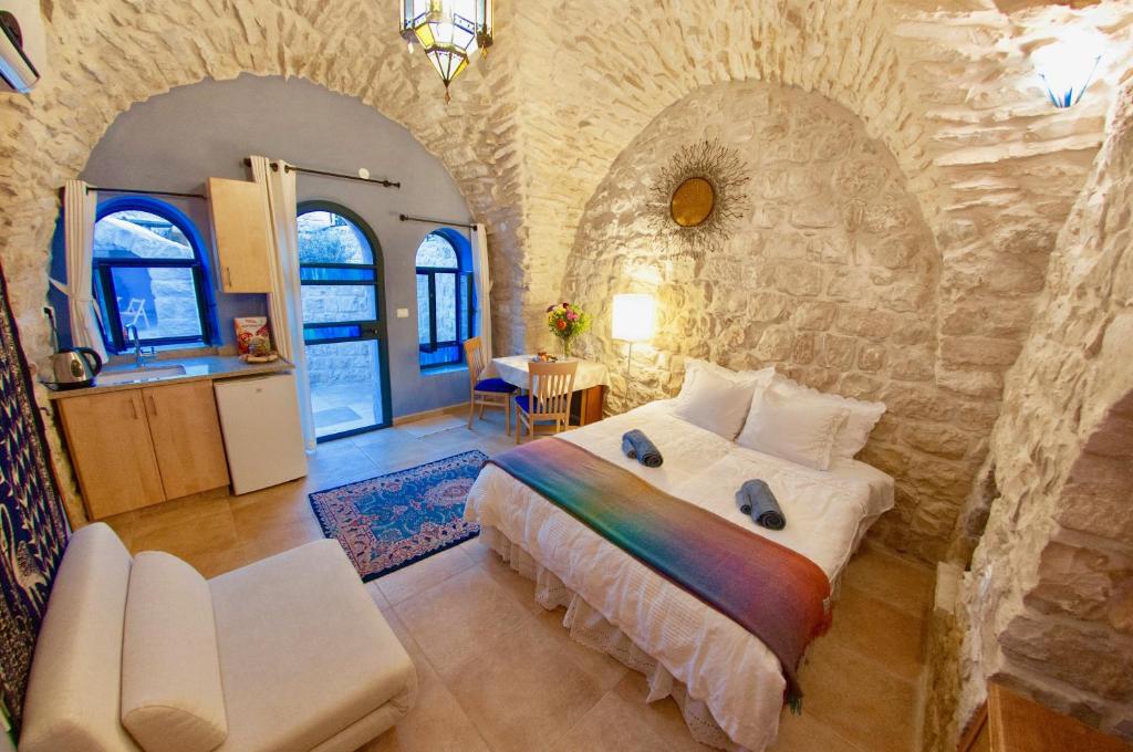 een slaapkamer met een groot bed in een stenen muur bij Artist Quarter Guesthouse B&B in Safed