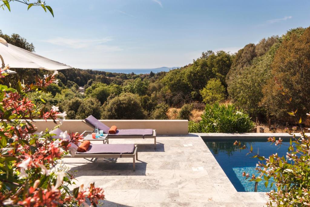 a villa with a swimming pool with a view at Le Ruone in Calcatoggio