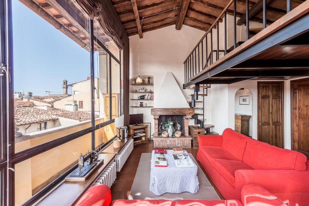 a living room with a red couch and a fireplace at Loggia panoramica in Florence