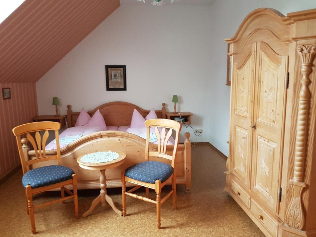 um quarto com uma cama, uma mesa e cadeiras em Gasthaus und Hotel Peterhänsel em Spechtsbrunn