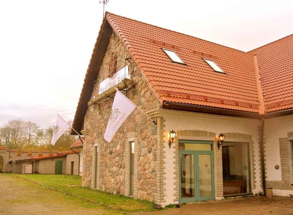 un bâtiment en pierre avec un toit rouge dans l'établissement Üksik Rüütel Hotel, à Kurna