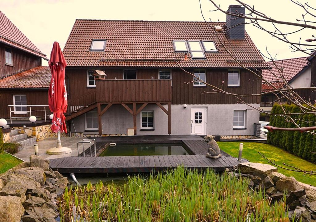 a house with a pond in front of it at Ferienhaus Brockenbäcker in Tanne