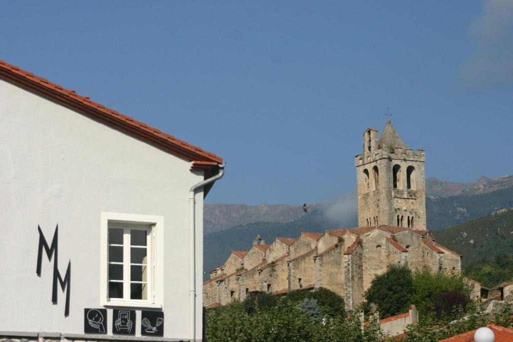 un edificio con una torre de reloj en el fondo en Maison Mauro, en Prats-de-Mollo-la-Preste