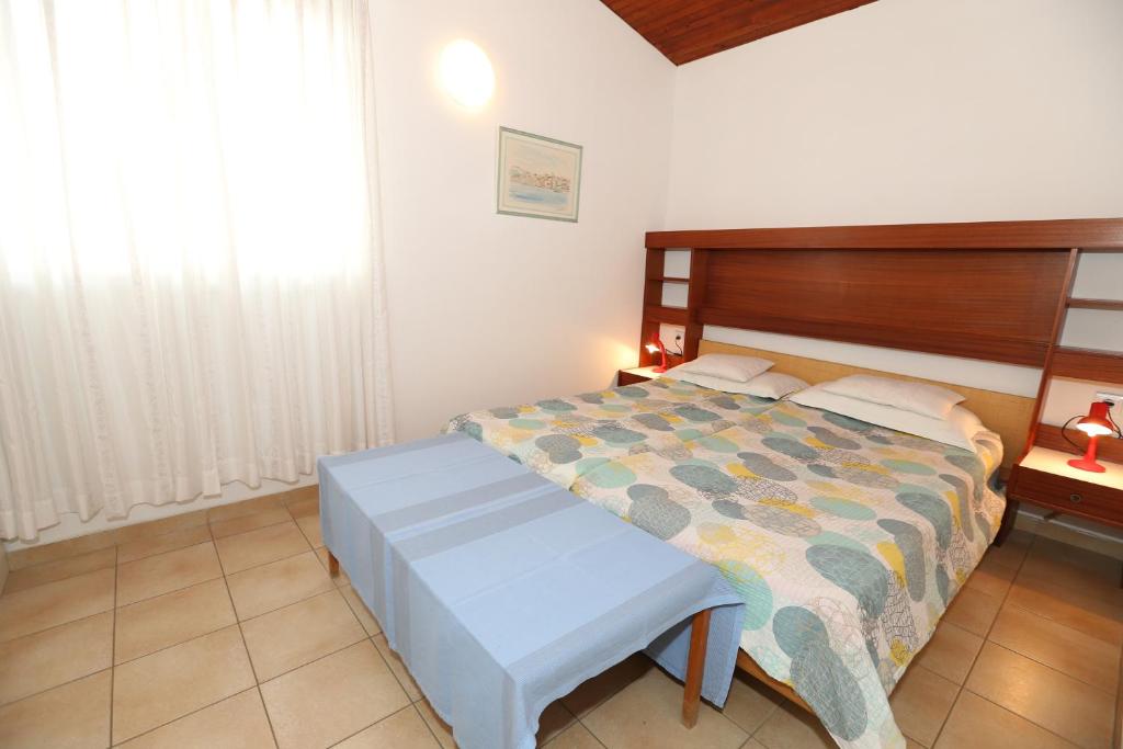 - une chambre avec un grand lit et une tête de lit en bois dans l'établissement Apartment Alan with Terrace, à Baška