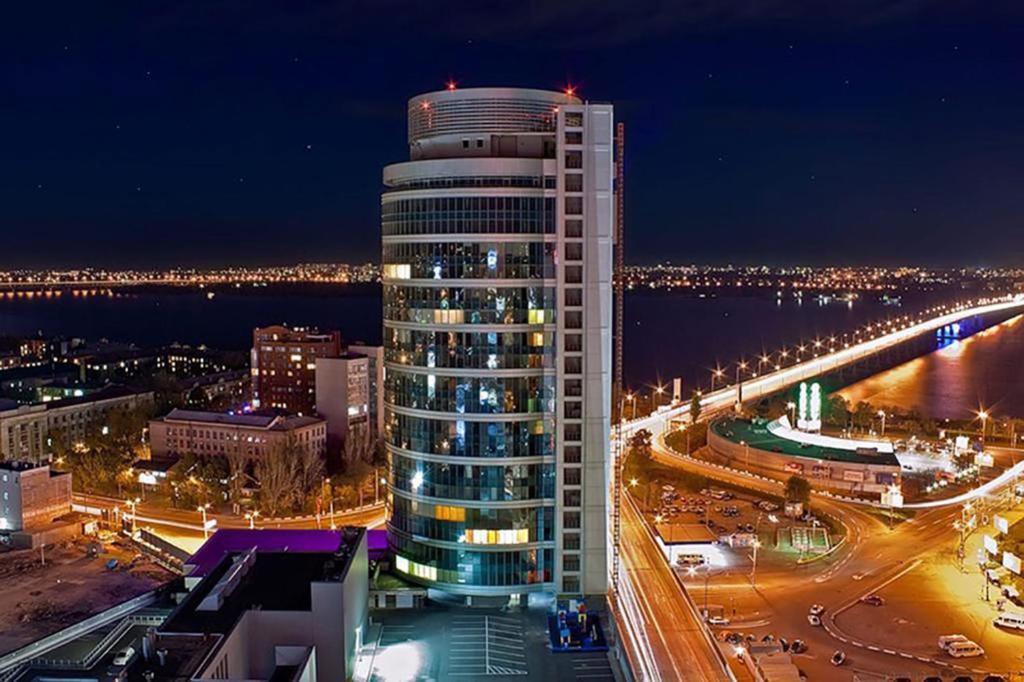 a tall building at night with a city at My Stay in Dnipro