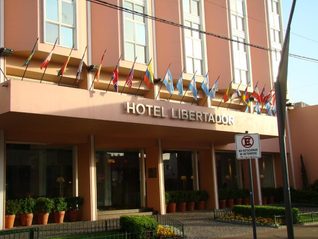 a hotel with flags on the front of a building at Hotel Libertador in Tandil