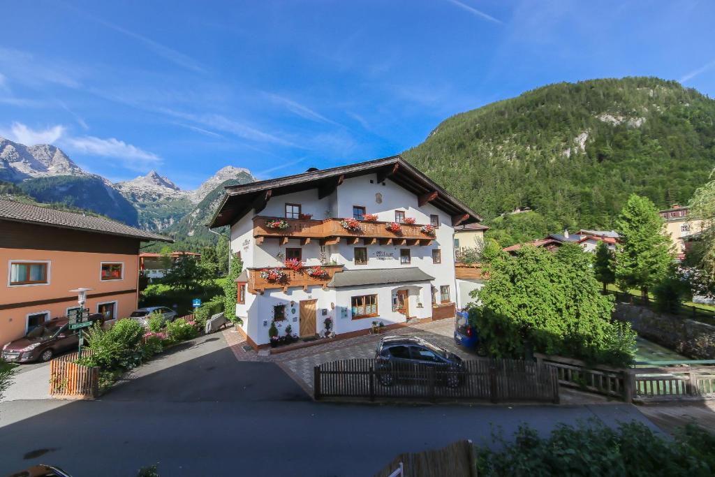 a large white house with mountains in the background at Appartements Millinger in Lofer