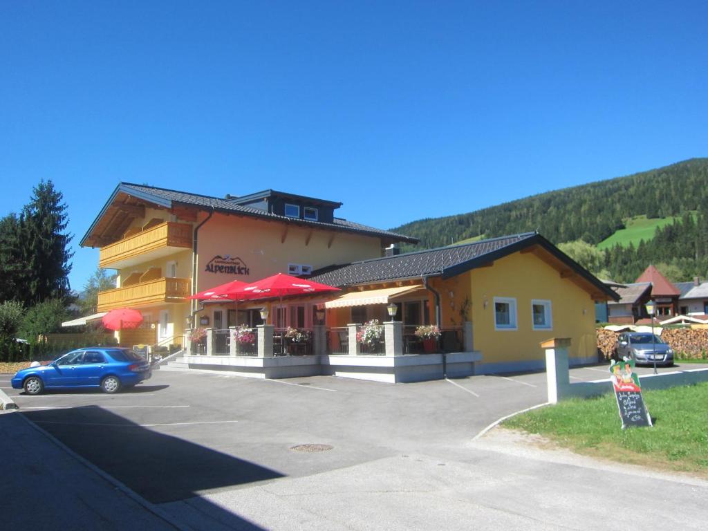 ein Gebäude mit einem Auto auf einem Parkplatz in der Unterkunft Landgasthof Alpenblick in Altenmarkt im Pongau