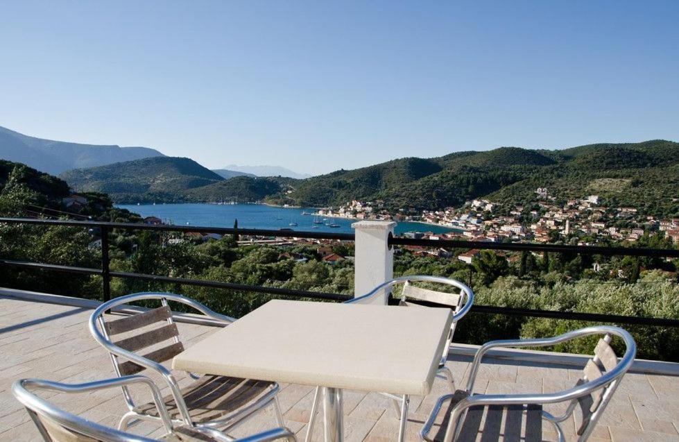 a white table and two chairs on a balcony with a view at Euktimeno in Vathi