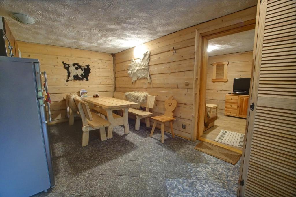 a dining room with a table and a refrigerator at Chata pod Skocznią in Szczyrk