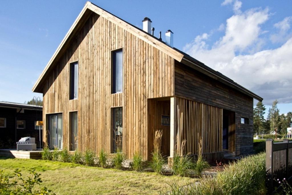 a wooden house with a gambrel roof at Marina Holiday Lotus Village in Imatra