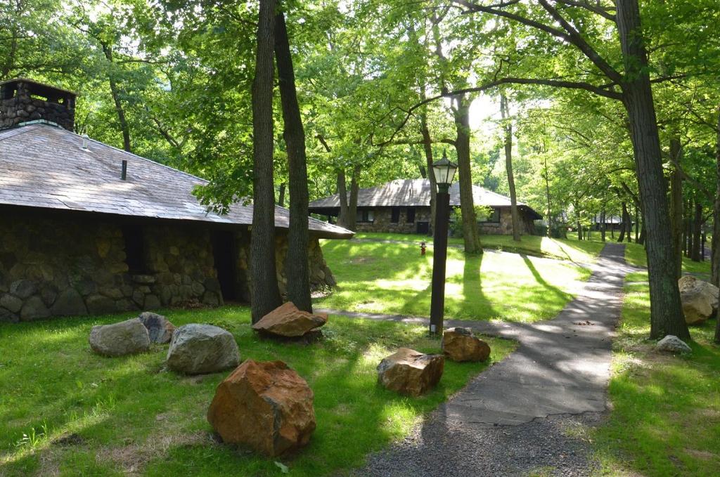 um jardim com pedras e árvores e um edifício em Overlook Lodge and Stone Cottages at Bear Mountain em Highland Falls