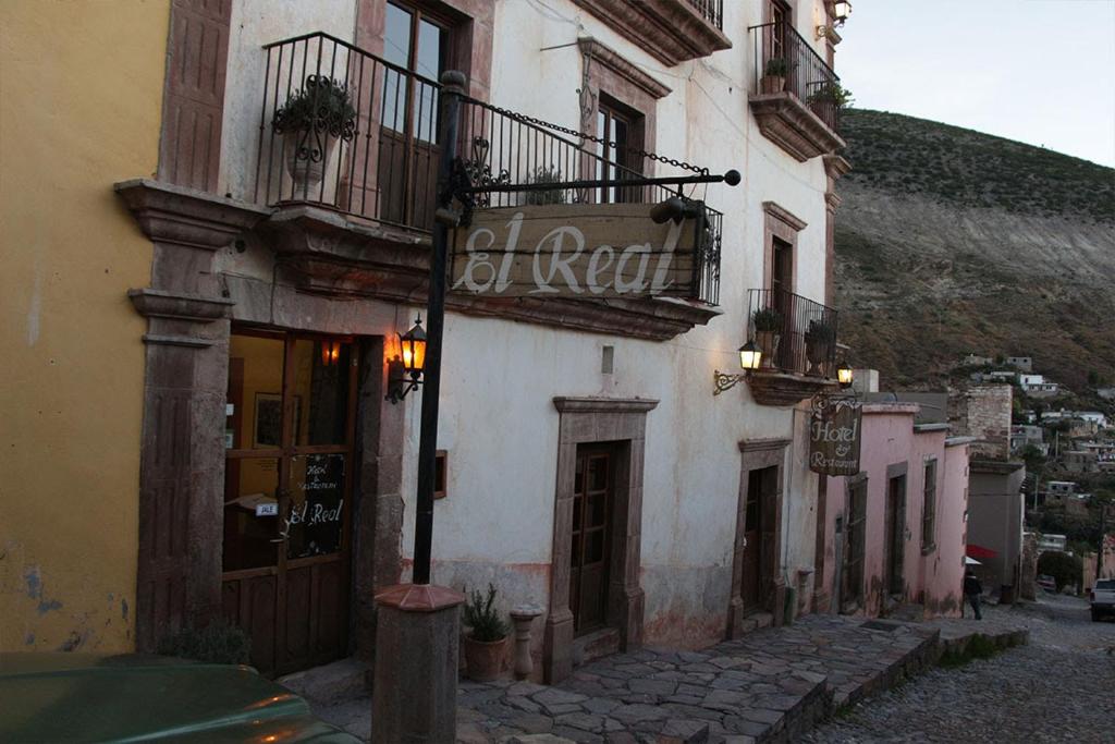 a building with a sign on it on a street at Hotel El Real in Real de Catorce