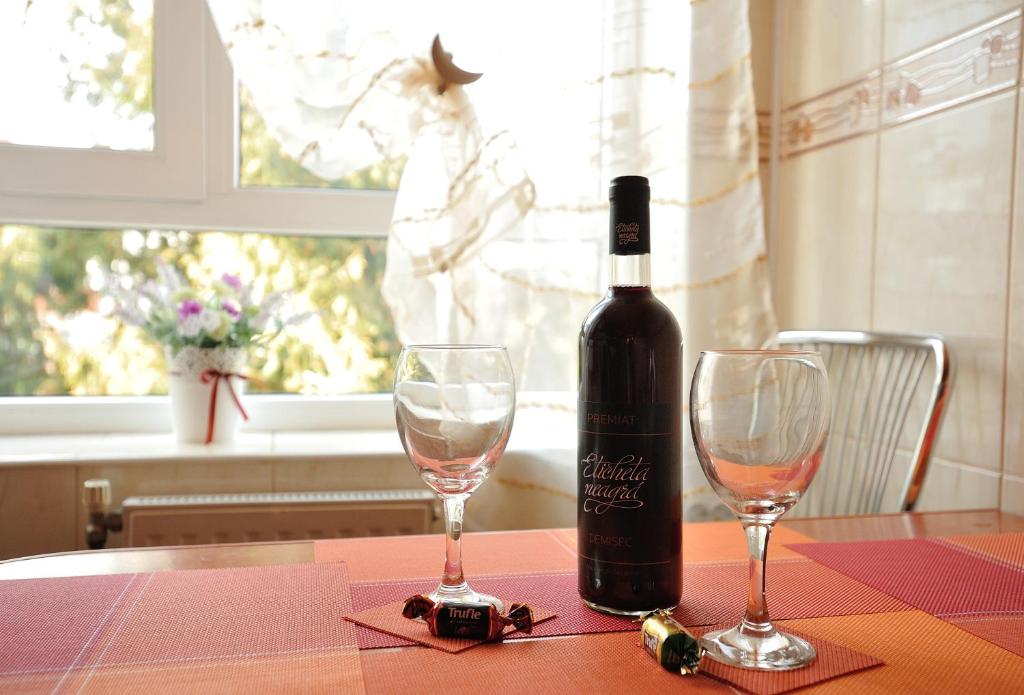 een fles wijn zittend op een tafel met twee glazen bij Stephanie Apartment in Braşov