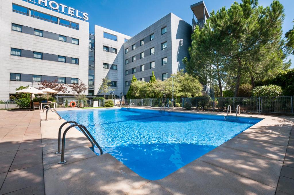 a swimming pool in front of a building at Exe Madrid Norte in Madrid