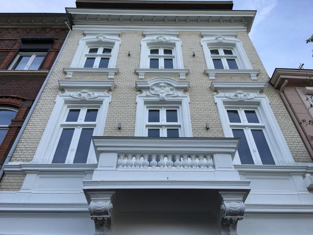 een hoog wit gebouw met ramen en een balkon bij Vaals - Aachen Apartaments in Vaals