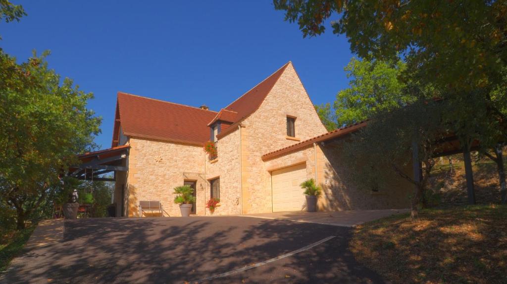 a large brick house with a garage at Magnifique Villa de prestige, piscine chauffée in Marnac