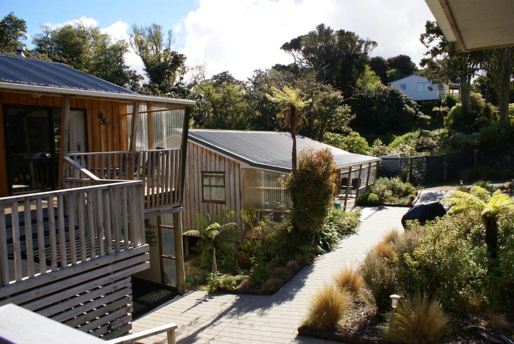 a garden with a row of wooden buildings at Kaka Retreat Motel, Stewart Island in Half-moon Bay