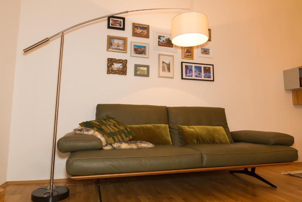 un sofá en una sala de estar con lámpara en Apartment Joanneum en Graz