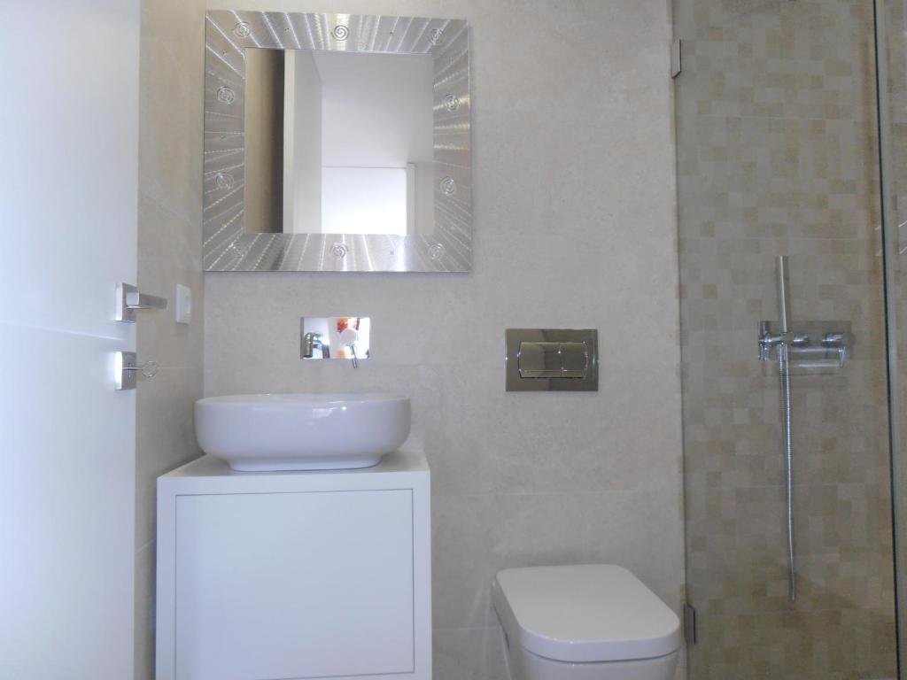 a bathroom with a toilet and a sink and a mirror at BC Porto Downtown Apartment in Porto