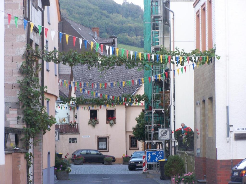 Una calle con un montón de banderas colgando entre edificios en Albergo Pensione, en Alf