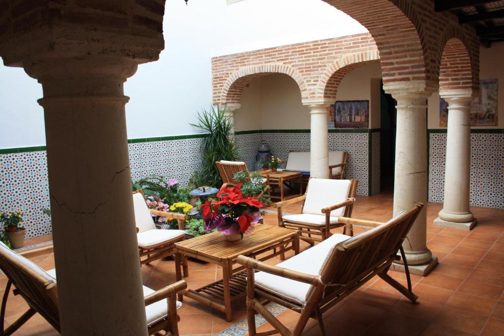 een patio met stoelen en een tafel met bloemen bij Casa Rural Sidonia in Medina Sidonia