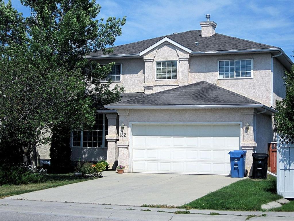 uma casa com uma porta de garagem branca em frente em Brother Li Homestay em Calgary