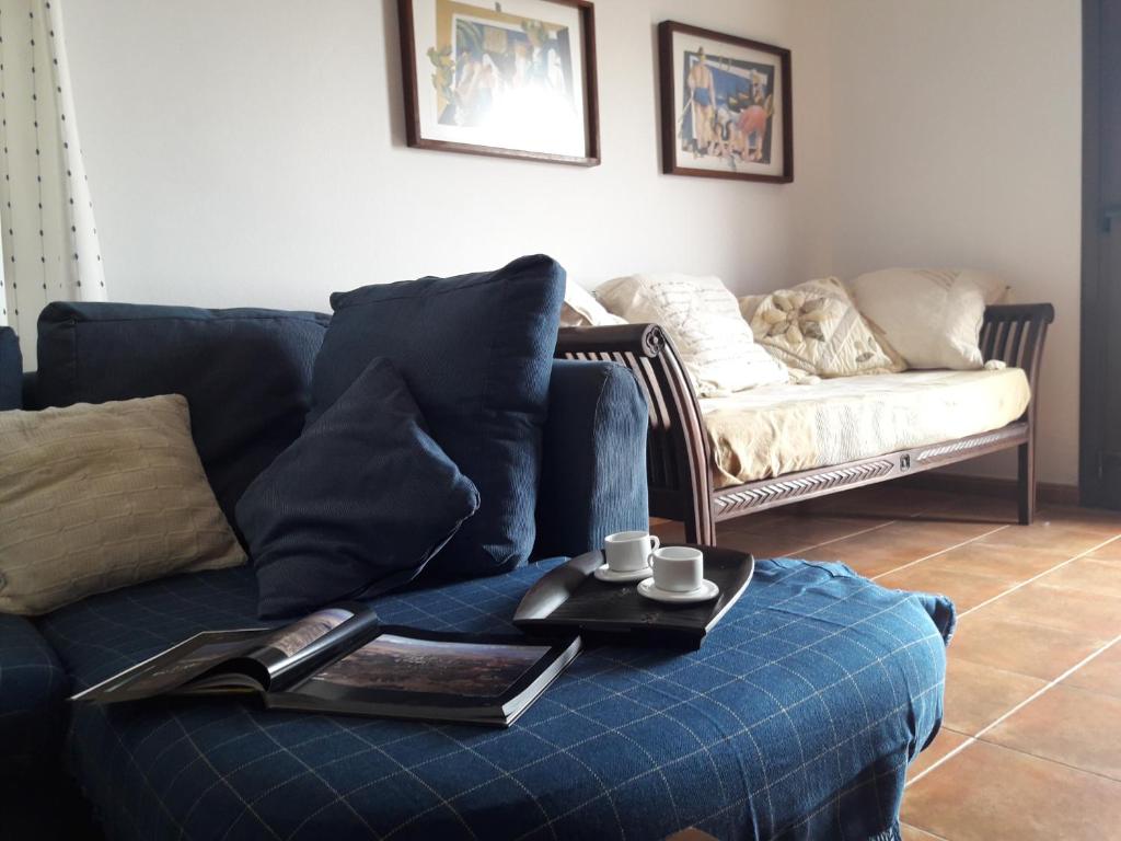 a living room with a blue couch with two cups on a tray at Casa Chona in Tinajo