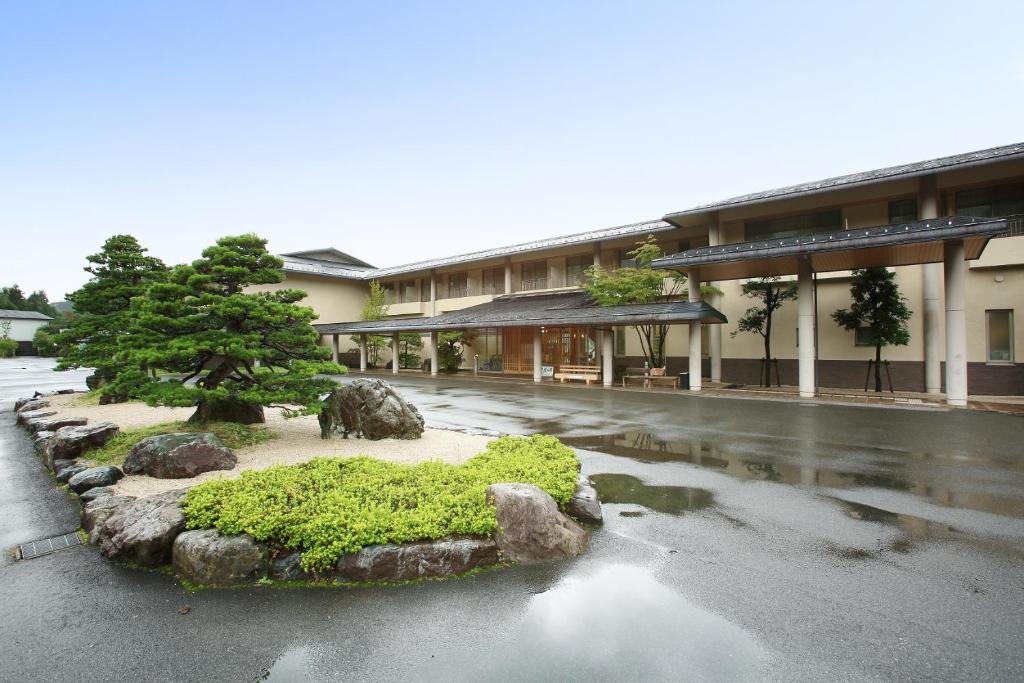 Okuizumo-cho的住宿－玉峰山莊日式旅館，街道中间有树的建筑