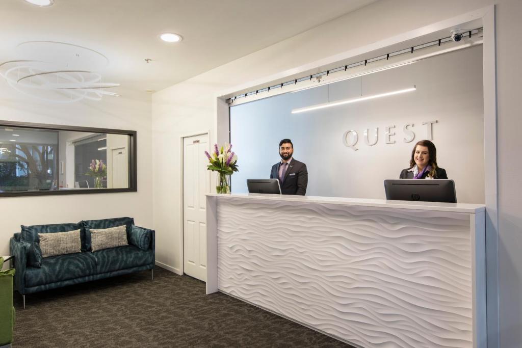 a man standing next to a woman in front of a podium at Quest Atrium Serviced Apartments in Wellington