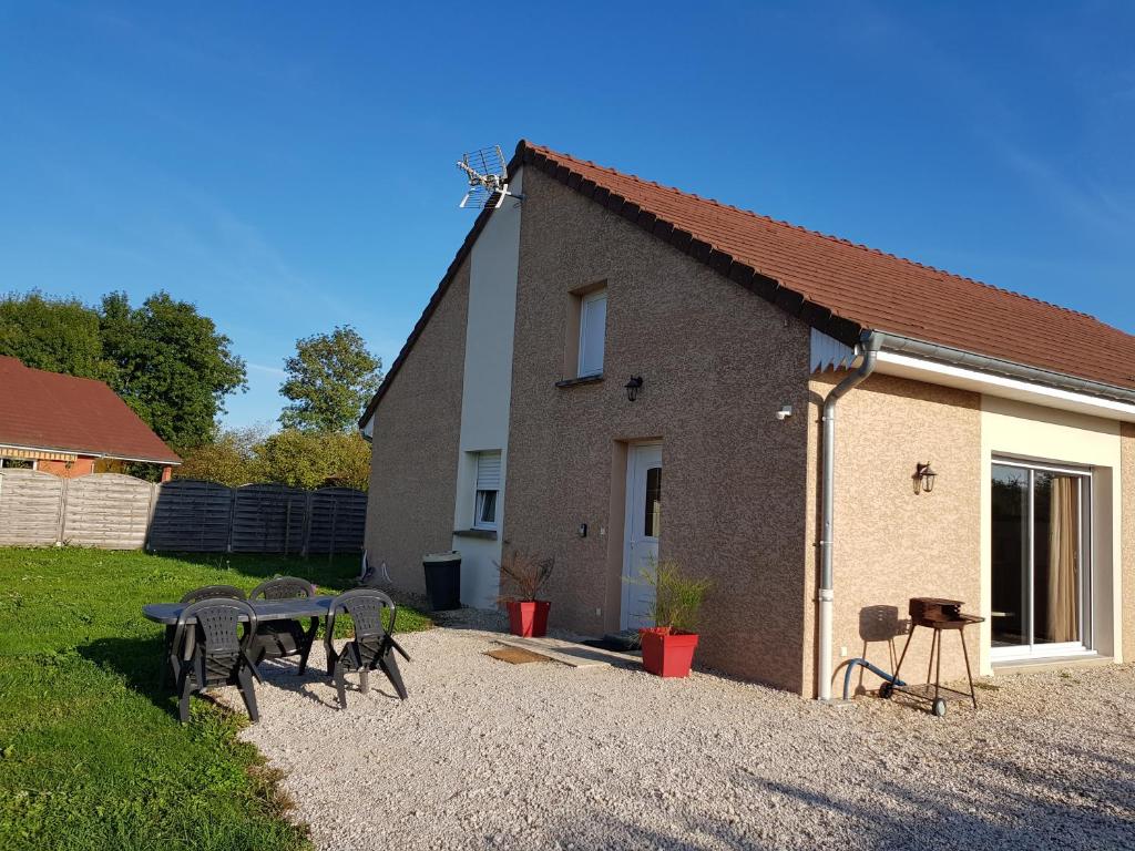 un grupo de sillas y una mesa frente a un edificio en Gite Le Petit Pied-à-Terre, en La Chapelle-Saint-Sauveur