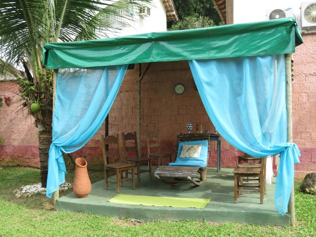 un dosel azul con una silla y una mesa en Casa Caiçara no Caborê, en Paraty