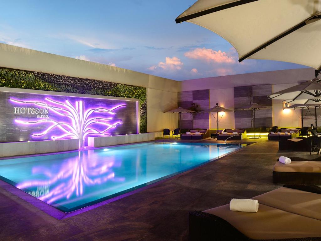 una piscina en un hotel con una palmera iluminada en HS HOTSSON Hotel Irapuato en Irapuato