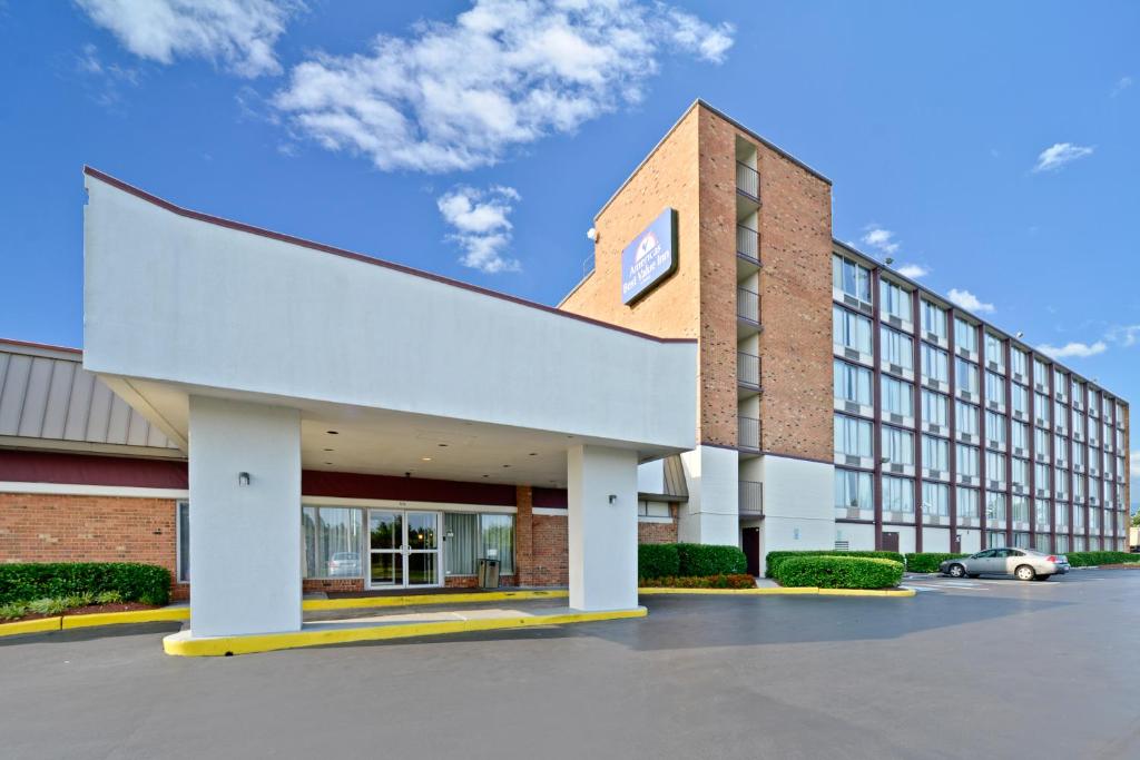 a building with a car parked in a parking lot at Americas Best Value Inn - Baltimore in Baltimore