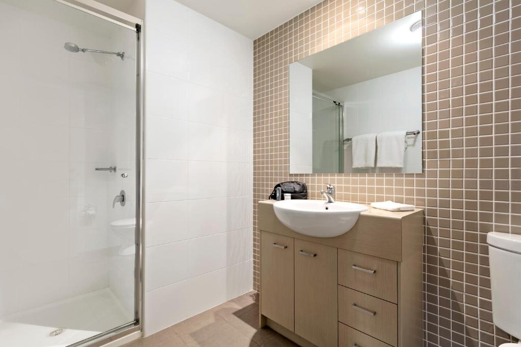 un bagno con lavandino e doccia di Quest Singleton a Singleton