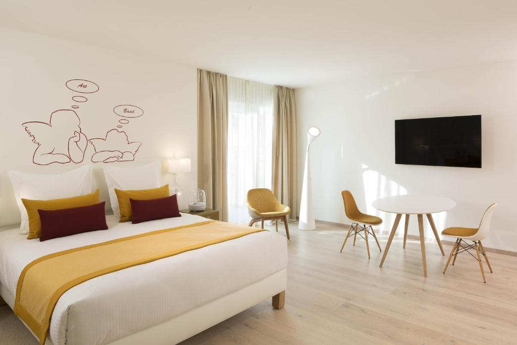 a bedroom with a bed and a table with chairs at The Passage - Urban Retreat in Basel