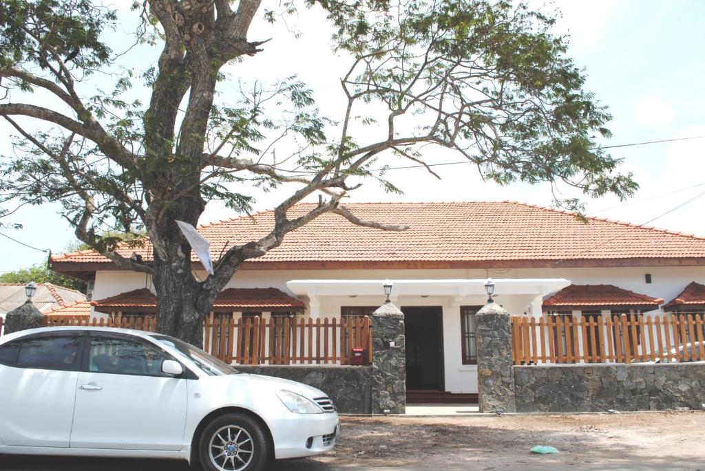 een witte auto geparkeerd voor een huis bij Miura Dutch Edge Hotel in Negombo
