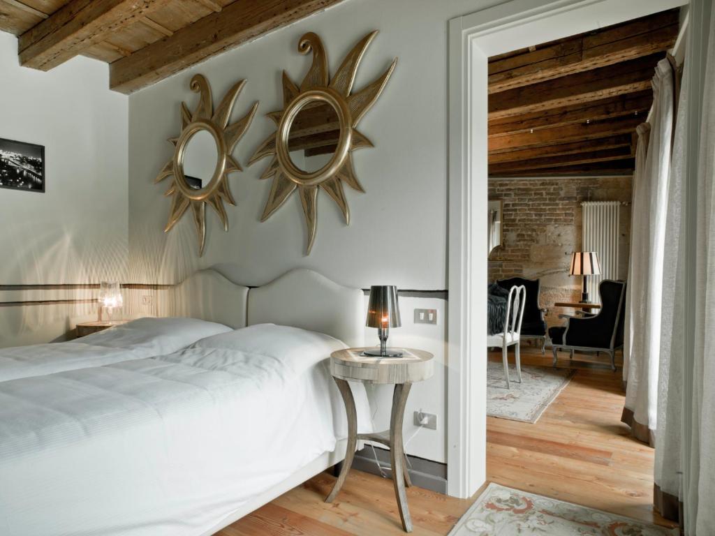 ヴェローナにあるSuite Ponte Pietraのベッドルーム1室(ベッド1台、壁に鏡2つ付)