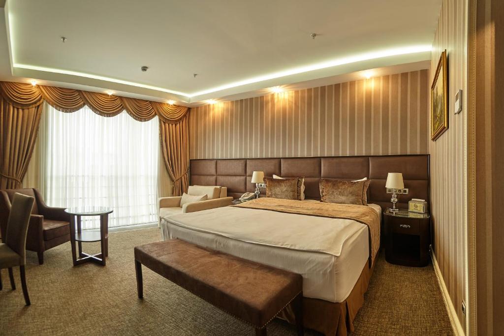 ein Hotelzimmer mit einem Bett, einem Stuhl und einem Sofa in der Unterkunft Boutique Hotel Buta in Minsk