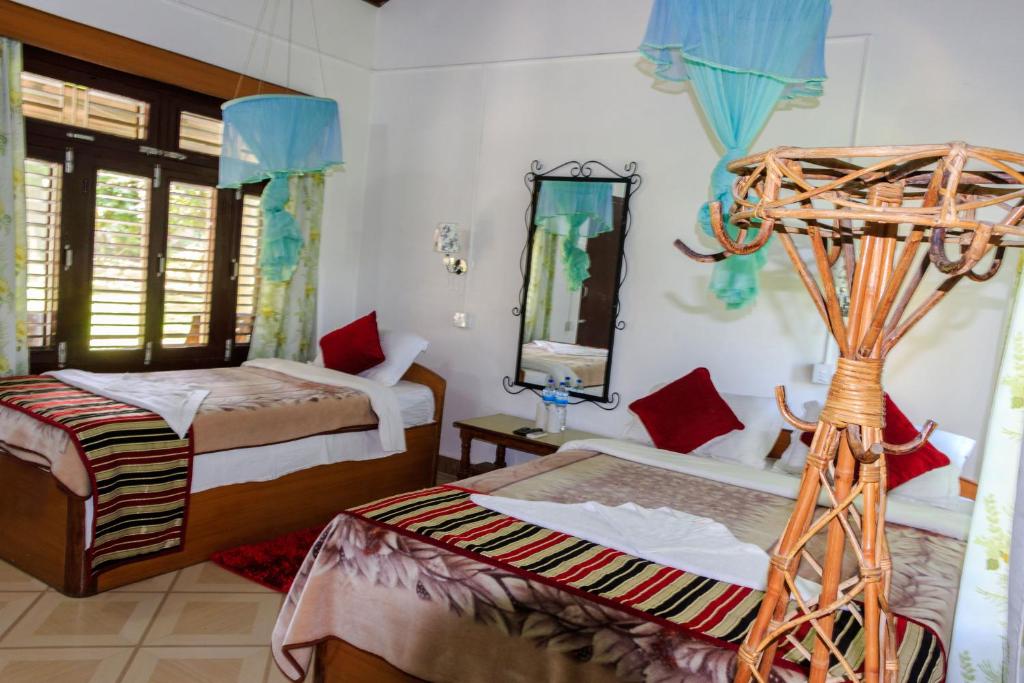 1 dormitorio con 2 camas y espejo en Tiger Residency Resort, en Sauraha