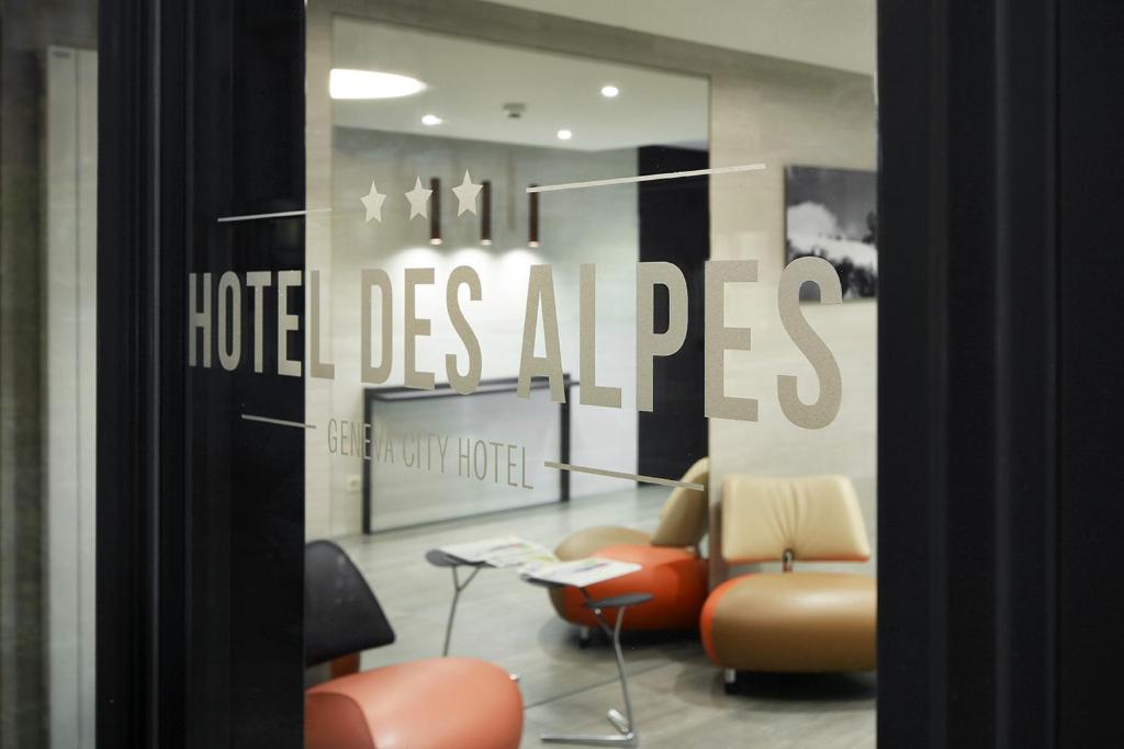 een hotelkamer met stoelen en een bord met hotelgas-apen bij Hotel des Alpes in Genève