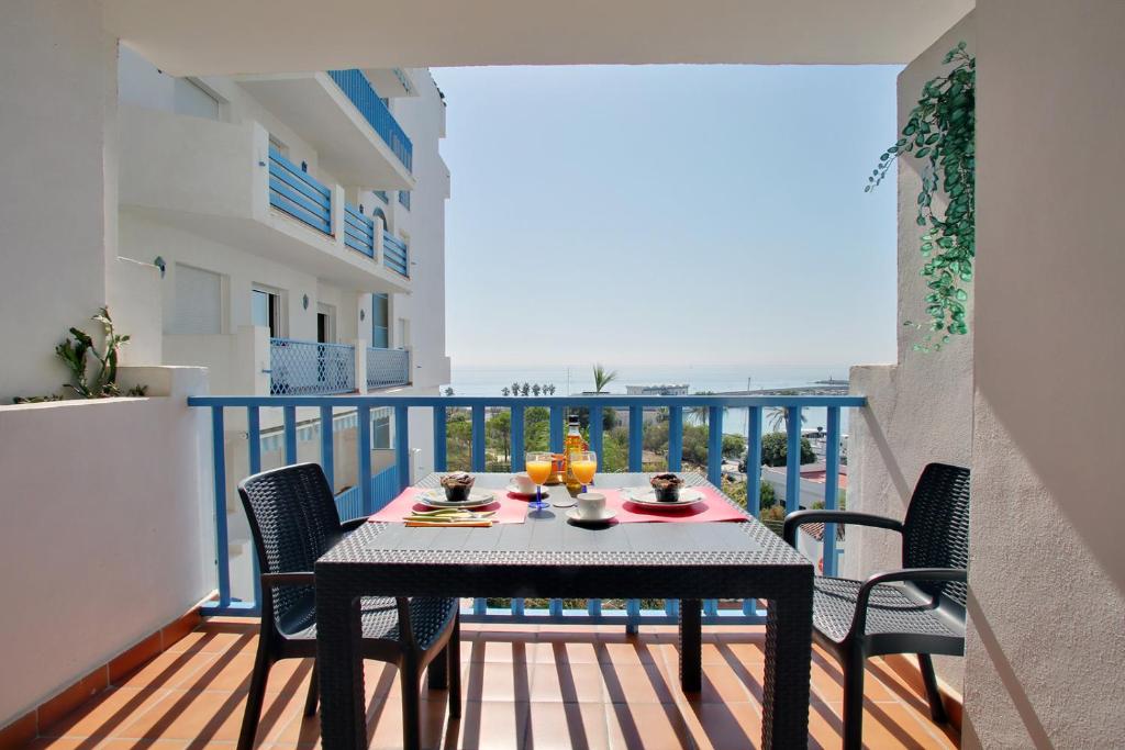 - Mesa de comedor en el balcón con vistas al océano en Apartamento El Faro Leisure Port, en Estepona