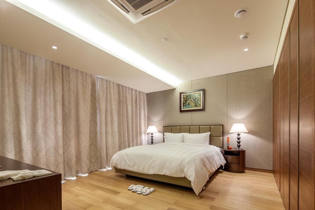 a hotel room with a bed and two lamps at Lotte The Residence in Hanoi