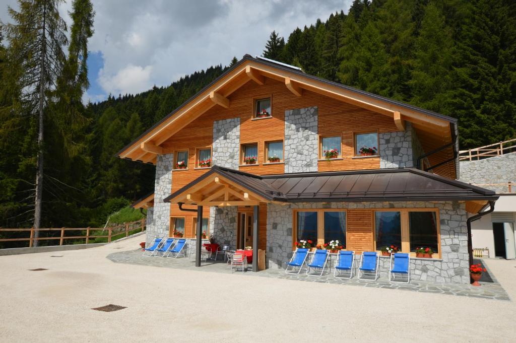 Roncegno的住宿－Chalet Serena，前面有蓝色椅子的房子