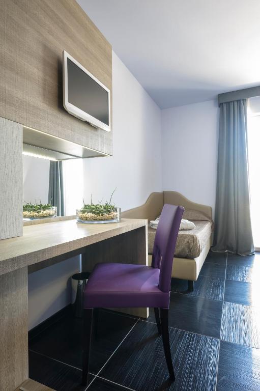 Televízia a/alebo spoločenská miestnosť v ubytovaní Le Dune Suite Hotel