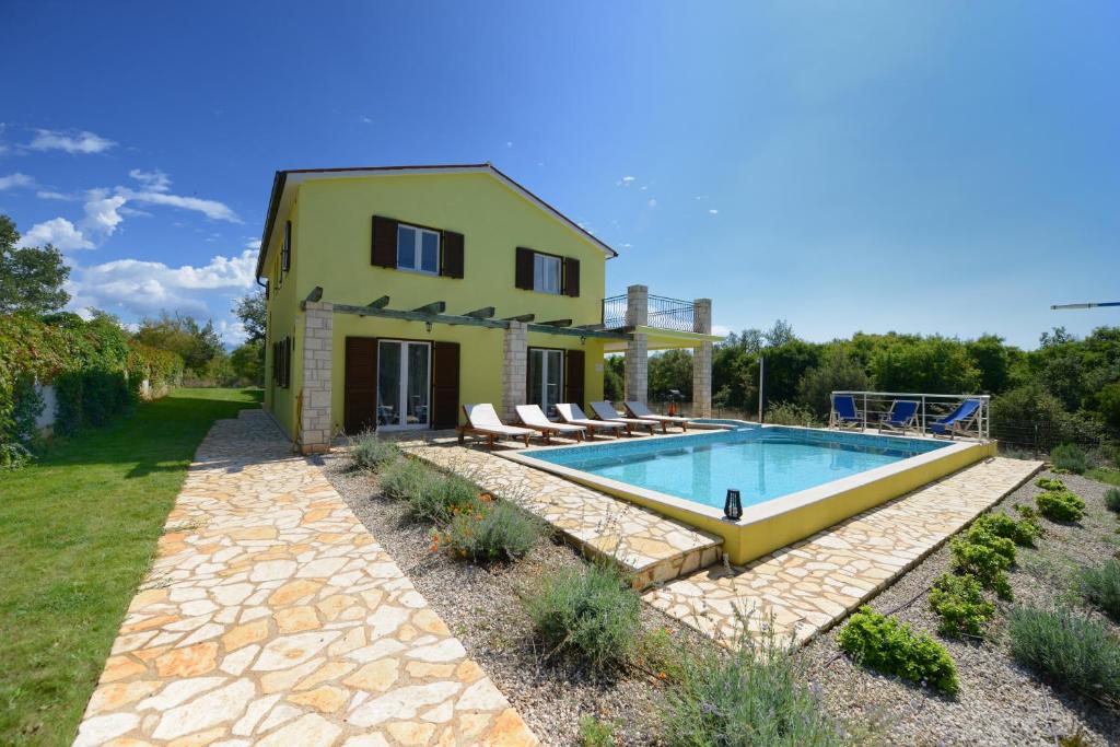 een huis met een zwembad in de tuin bij Villa Kontesici 14 in Zelena Laguna